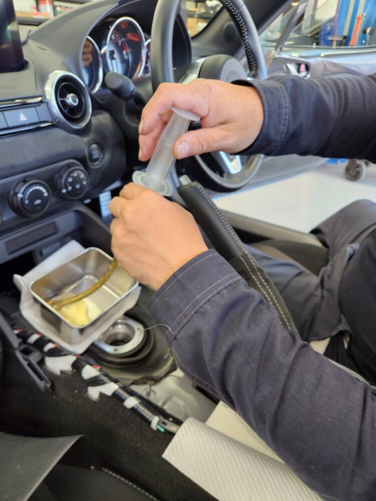NDロードスターのエクステンションハウジングからシリンジでオイルを抜く作業