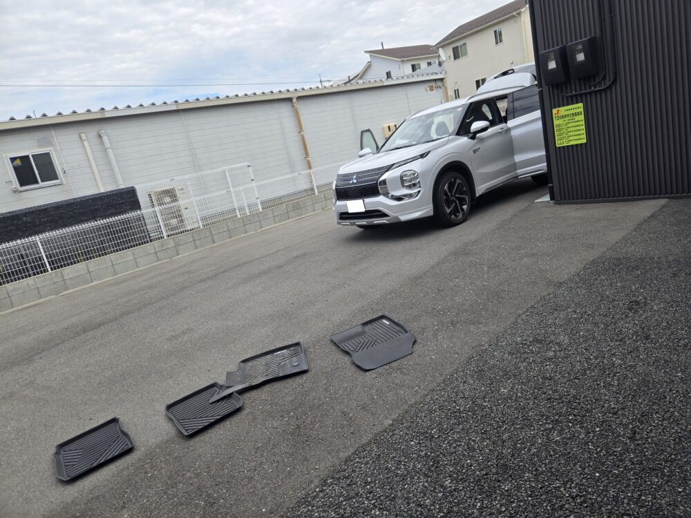 オークション出品前に清掃する白いアウトランダーPHEV